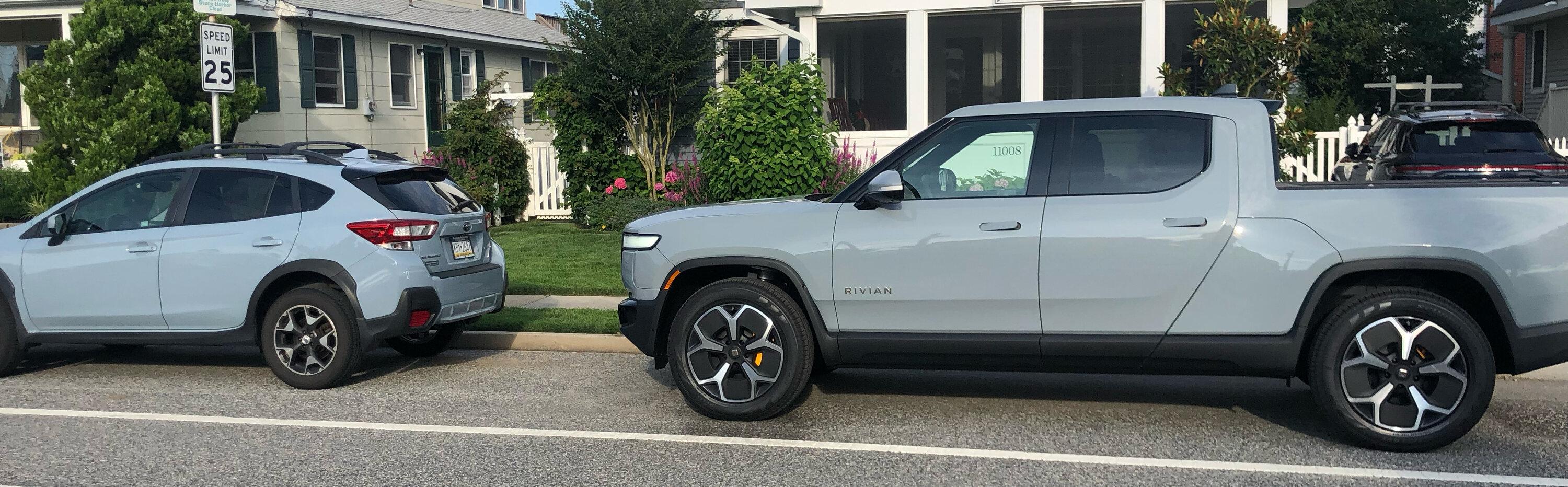Rivian R1T R1S Limestone next to Subaru's light blue Rivian Limestone next to Subaru