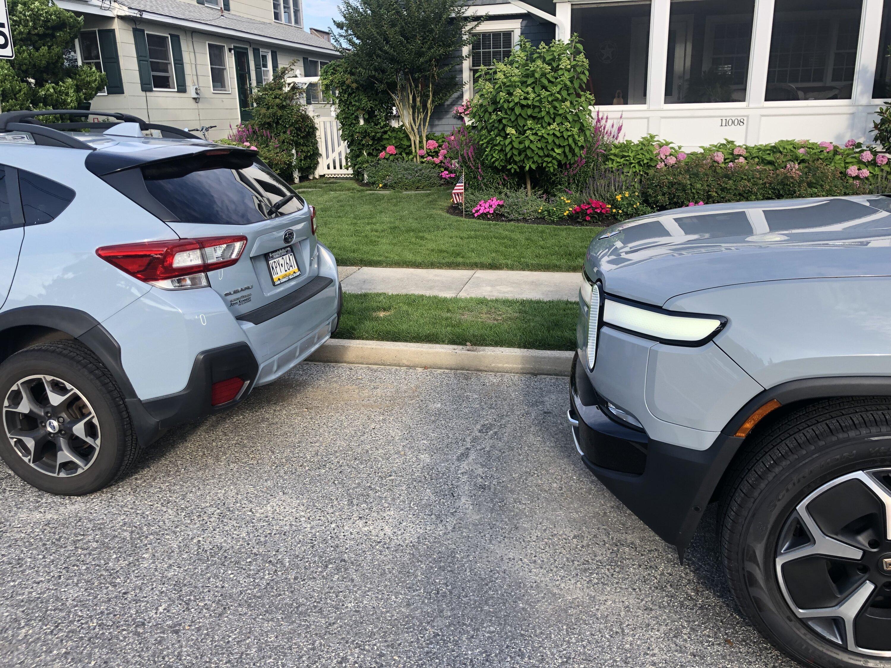 Rivian R1T R1S Limestone next to Subaru's light blue Rivian Limestone next to Subaru 2