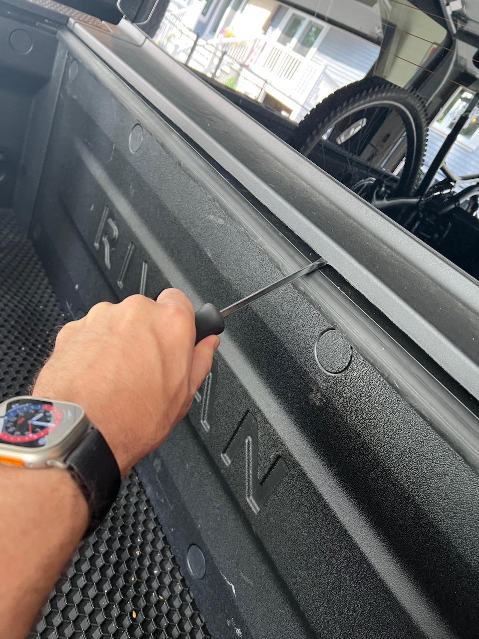 Rivian R1T R1S Rock stuck under auto tonneau cover cap IMG_0954