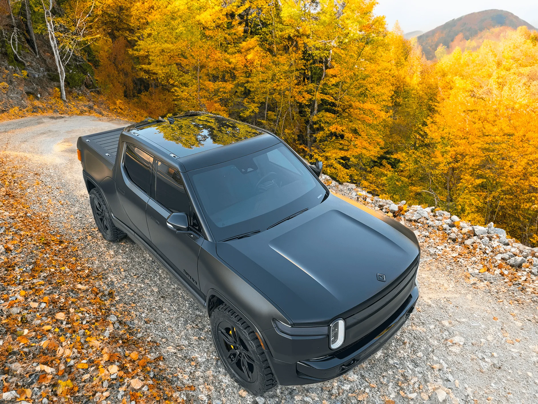Rivian R1T R1S Project Midnight R1T Top down in mountains with autumn leaves 2 small