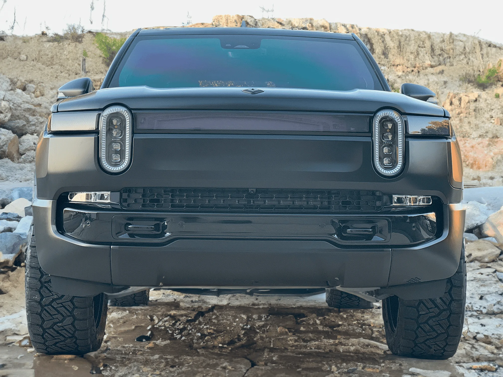 Rivian R1T R1S Project Midnight R1T Front View lights off driving on rock small