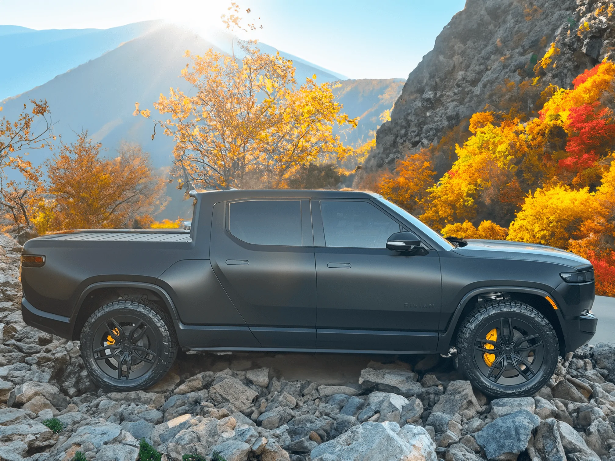 Rivian R1T R1S Project Midnight R1T assenger-view-on-the-rocks-autumn-leaves-small-png