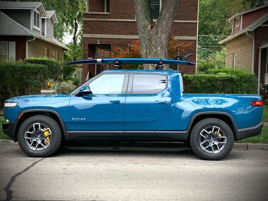 Rivian R1T R1S RIVIAN BLUE Rivian Photos Rivian R1T Yakima SUPDawg on Rivian roof rack bars - holding surfboard 5