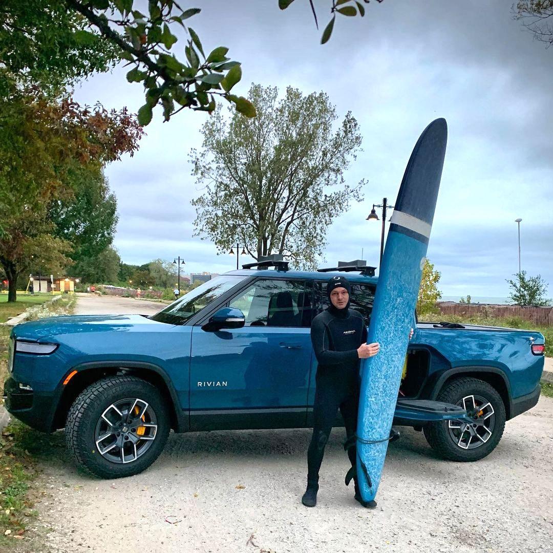 Rivian R1T R1S RIVIAN BLUE Rivian Photos Rivian R1T Yakima SUPDawg on Rivian roof rack bars - holding surfboard 1