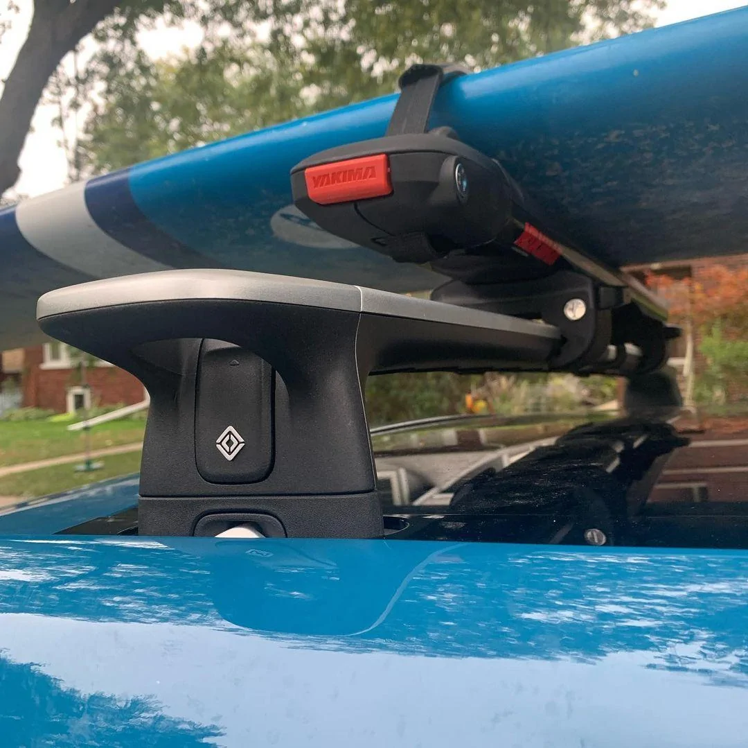 Rivian R1T R1S RIVIAN BLUE Rivian Photos Rivian R1T Yakima SUPDawg on Rivian roof rack bars - holding surfboard 3