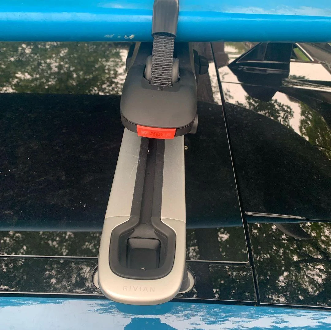 Rivian R1T R1S RIVIAN BLUE Rivian Photos Rivian R1T Yakima SUPDawg on Rivian roof rack bars - holding surfboard 2