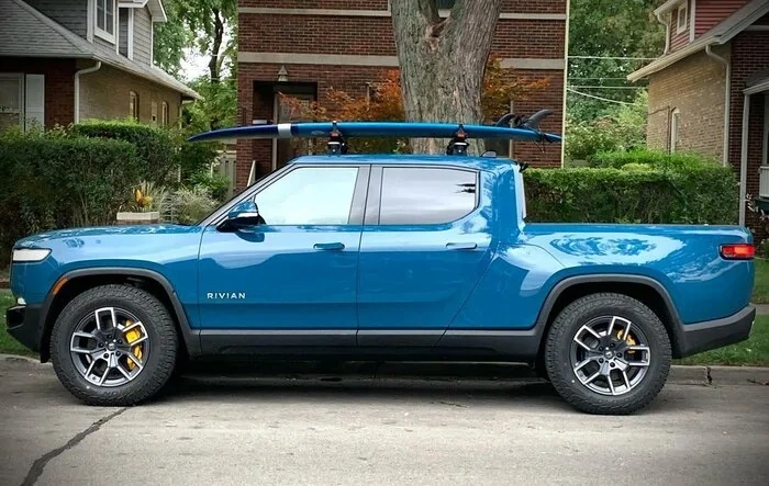 Yakima SUPDawg SUP Rack on Rivian R1T roof rack bars - carrying surfboard
