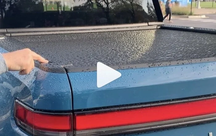 Watch the R1T tonneau cover roll up automatically (with water on top)